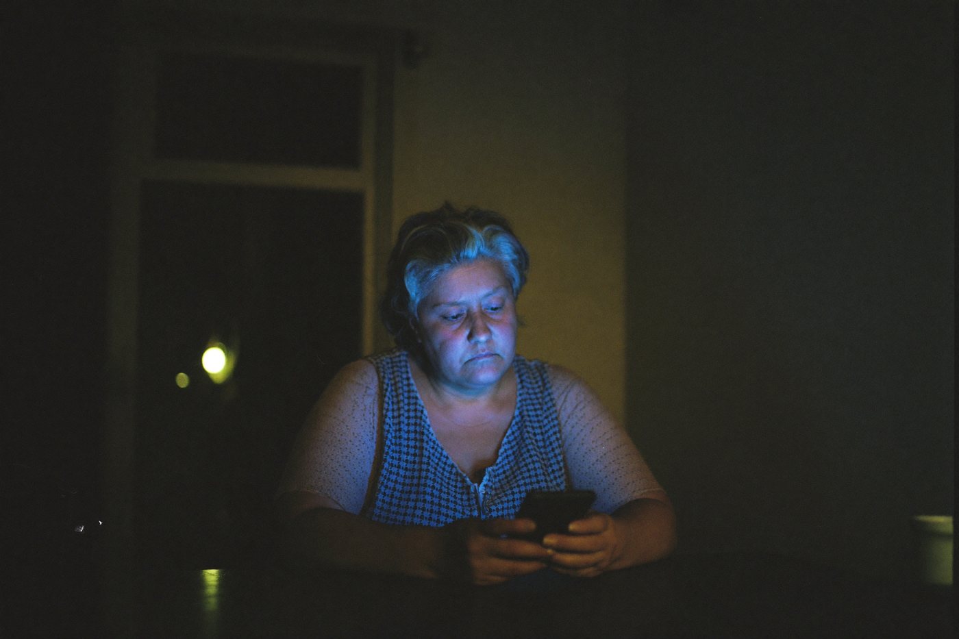 Pessoa olhando o celular à noite, sem vendas